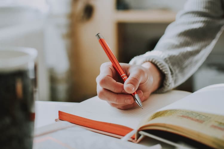 Person drawing in notebook
