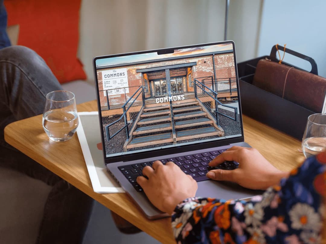 Person working at a computer showing The Commons website